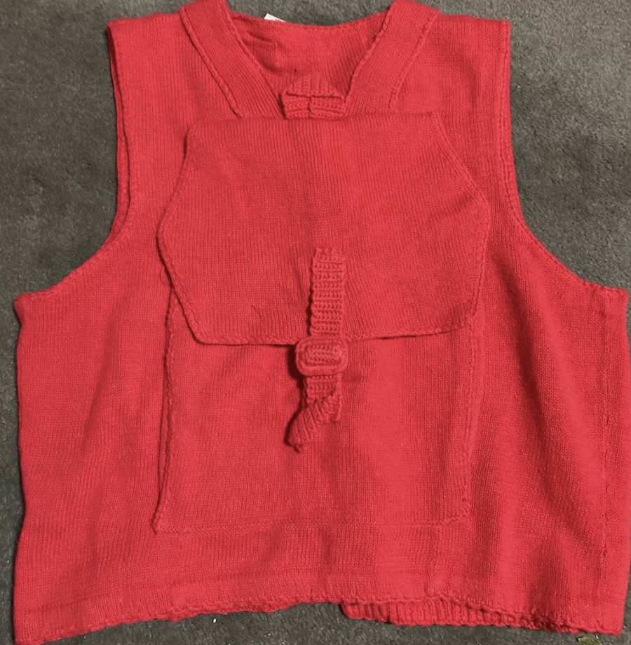 the back of a red button-up vest, with a knit backpack attached