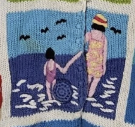 close-up of an applique family walking down the beach