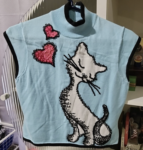 a mockneck knit tank top with a white cat and a red heart