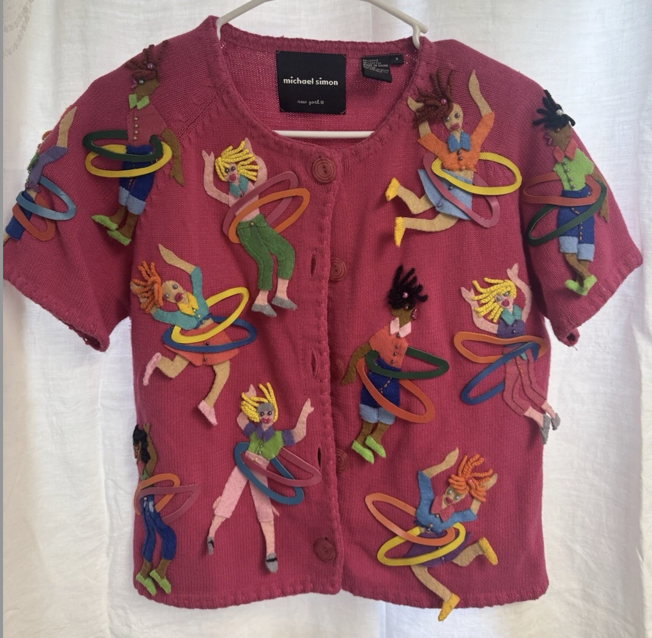 short-sleeved cardigan with colorful felt appliques of people hula hooping
