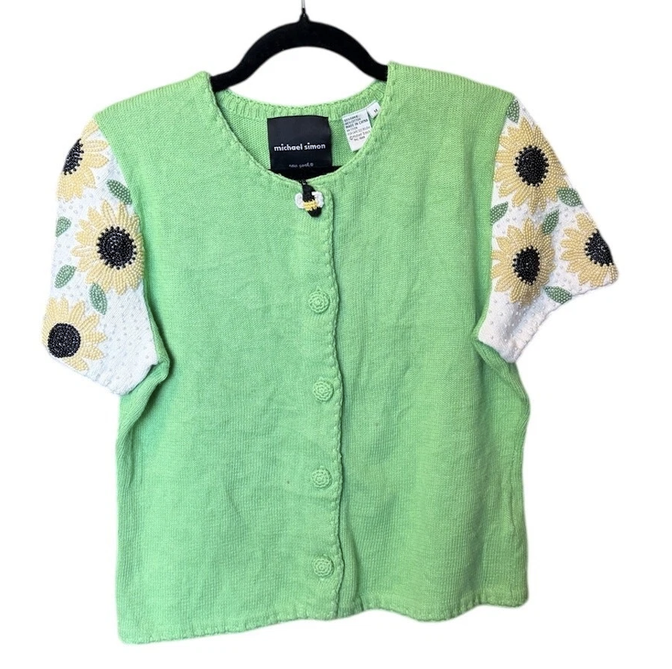 green short-sleeved cardigan with beaded sunflowers on the sleeves and a large bee button at the top